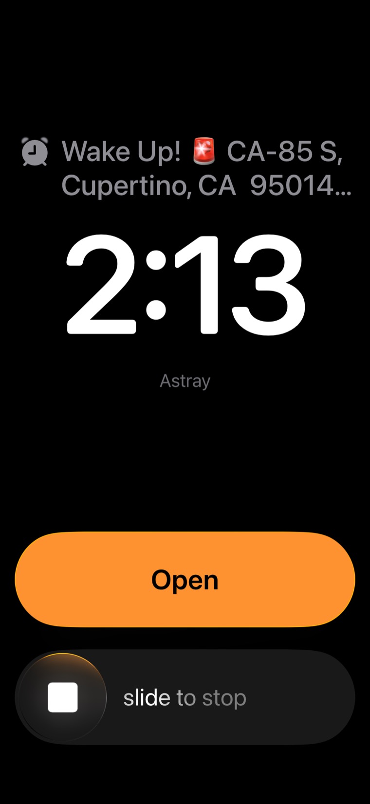 Astray's alarm on the iPhone lock screen: a Wake Up! headline with the destination address above the clock, an orange Open button, and a slide to stop control