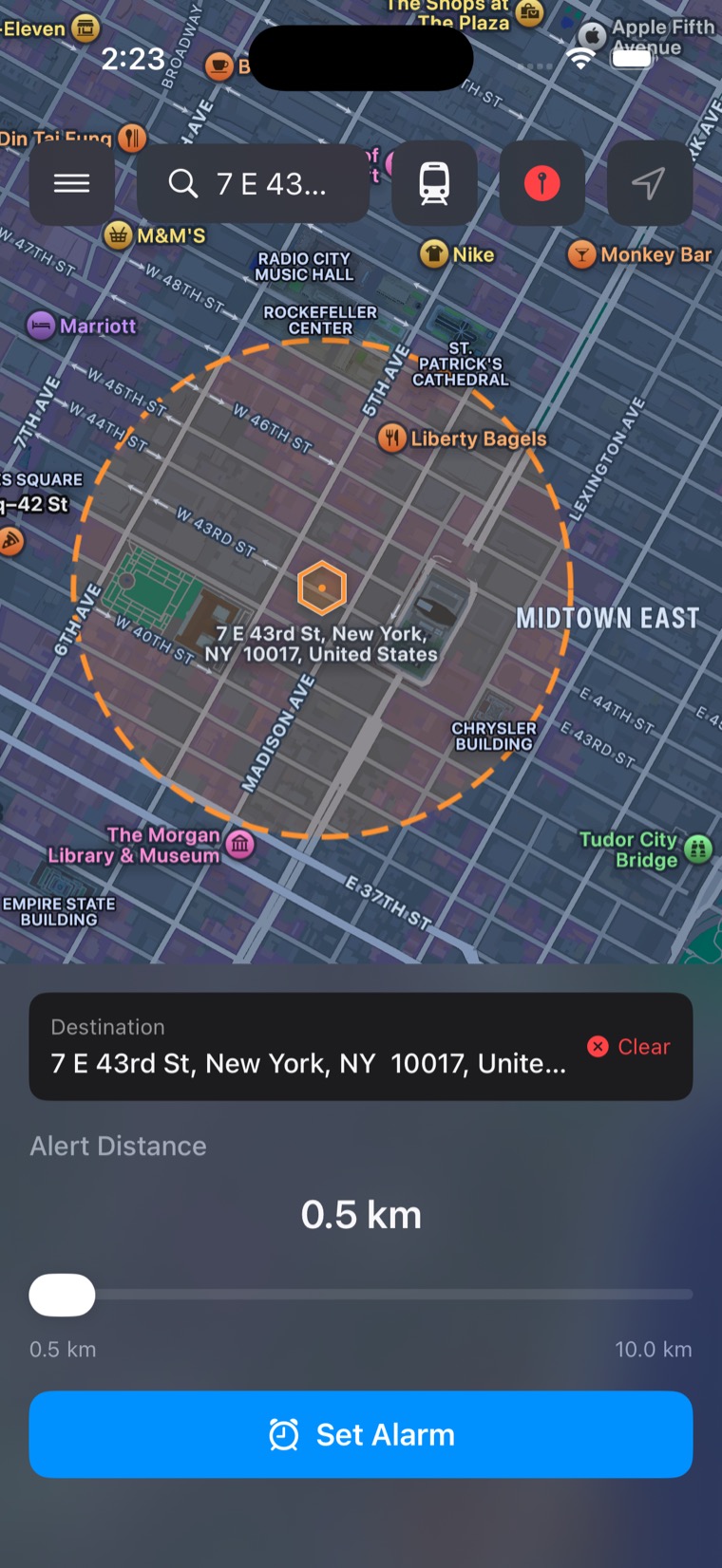 Astray's alarm setup screen: a dashed orange ring drawn around a New York address, a Destination row with Clear, an Alert Distance slider reading 0.5 km, and a blue Set Alarm button
